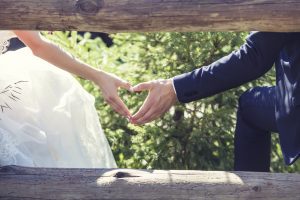 Bride and groom making heart with hands